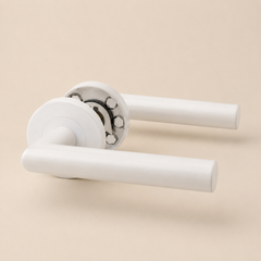 Detail van witte minimalistische deurklink met ronde greep
