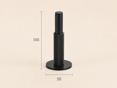 Detail van zwarte gekartelde messing deurstopper met rubberen buffer