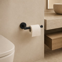 Zwarte toiletrolhouder met diamantstructuur gemonteerd in een warme minimalistische badkamer met beige tinten